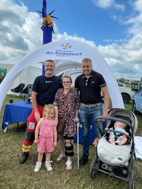 Abigail and her family at cheshire show stood with Critical Care Paramedic Martin in front of the Charity's events gazebo 