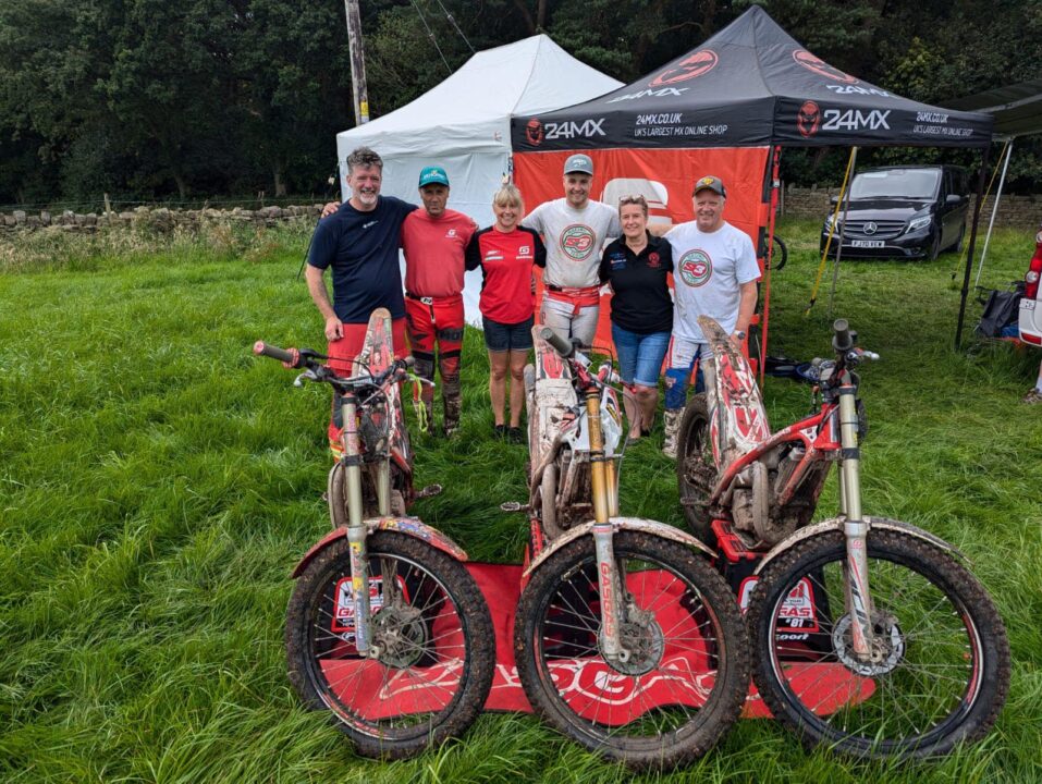 Trials bike riders stood with their bikes in front of a branded gazebo with critical care paramedic Mikey