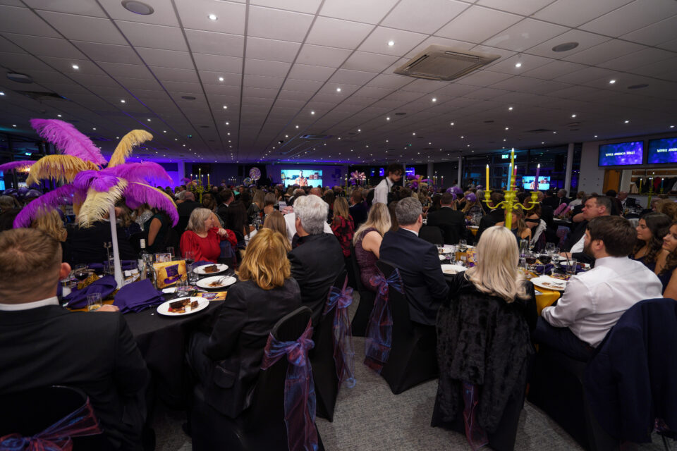 Room filled with people all sat at tables at the awards night