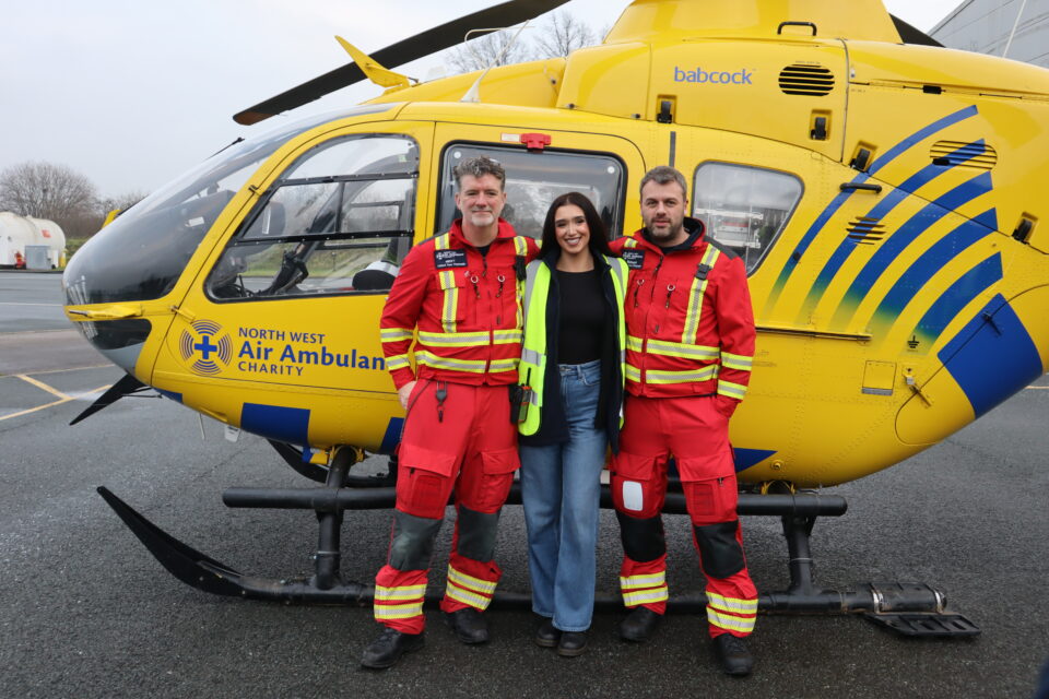 Georgia, wearing blue jeans and a black top, stood with the NWAA's critical care paramedics, who are wearing red flight suits